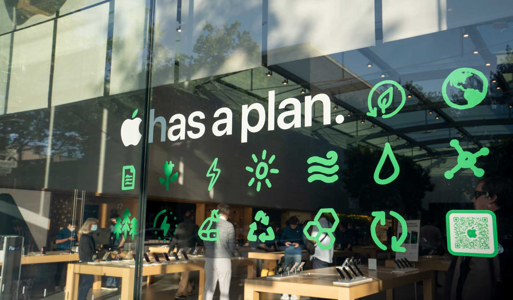 "Das Schaufenster eines Apple Stores ist mit einem "Apple hat einen Plan"-Schild versehen, das das Engagement des Unternehmens für den ökologischen Fortschritt demonstriert." 