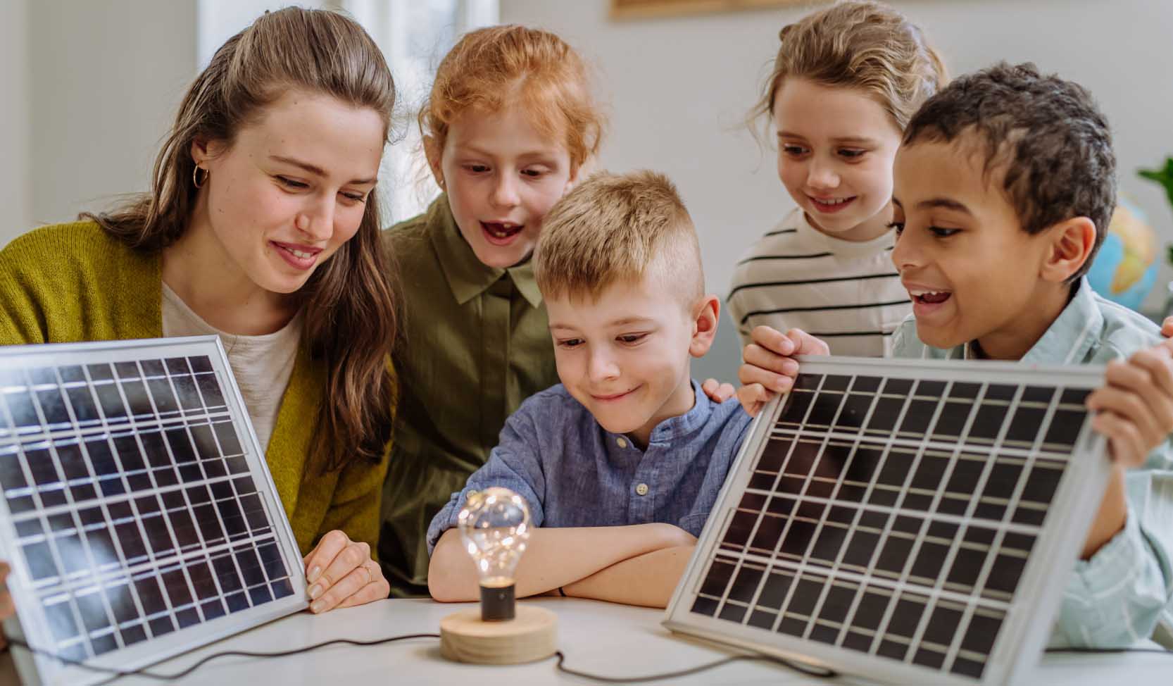"Um den Planeten zu retten, zeigt eine Lehrerin einer Klasse von Kindern, wie man mit erneuerbaren Energien Strom erzeugt."  
